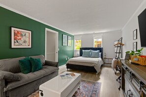 Ett modernt sovrum med en säng, en soffa och ett soffbord.