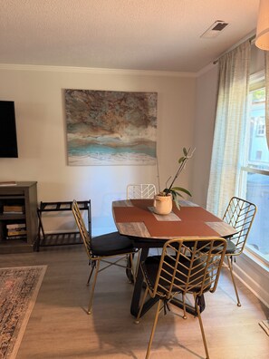 A dining area with a table, chairs, and a painting on the wall. - Spiritual Retreat on 12-Acres in Travelers Rest - Sauna, Cold Plunge, Hottub (Travelers Rest)