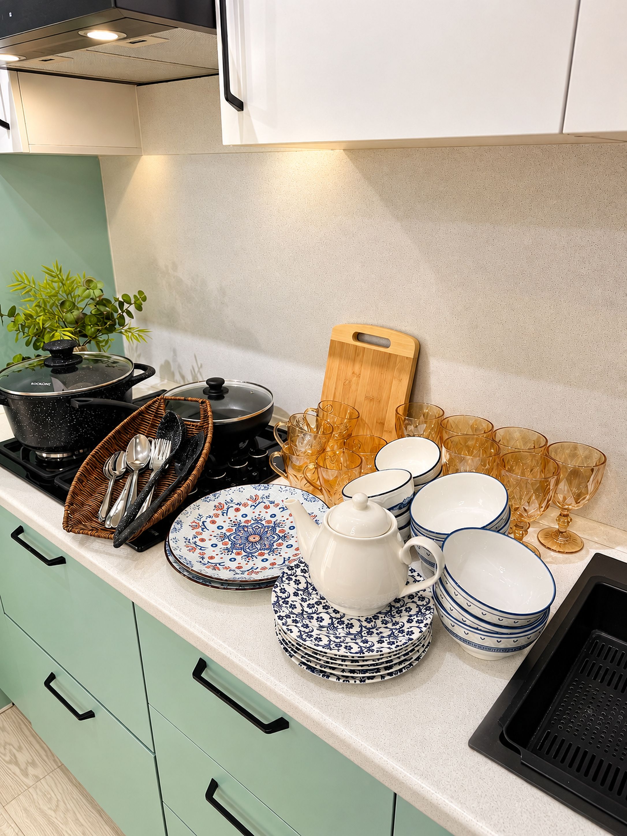 A kitchen counter with various dishes, a cutting board, and a plant.