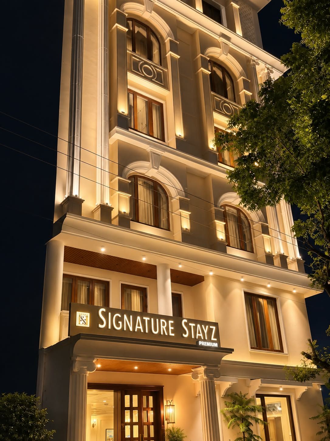 Un hotel de varios pisos con un letrero destacado que dice 'Signature Stayz Premium'.