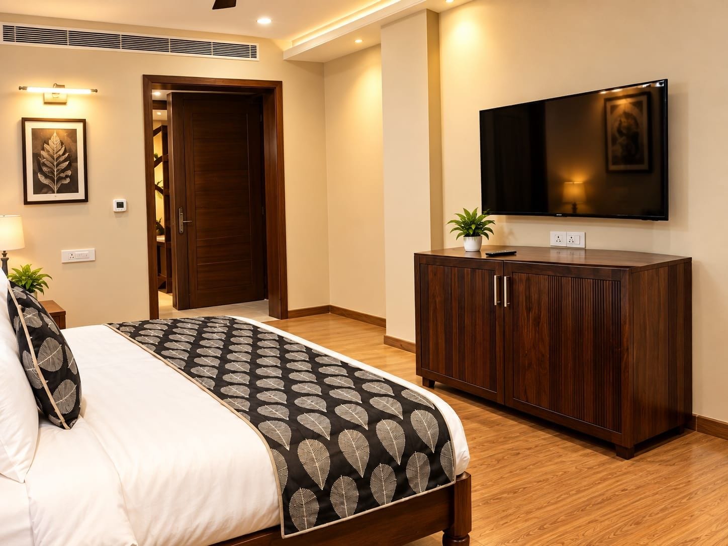 Un dormitorio con cama, armario, televisor y una planta.