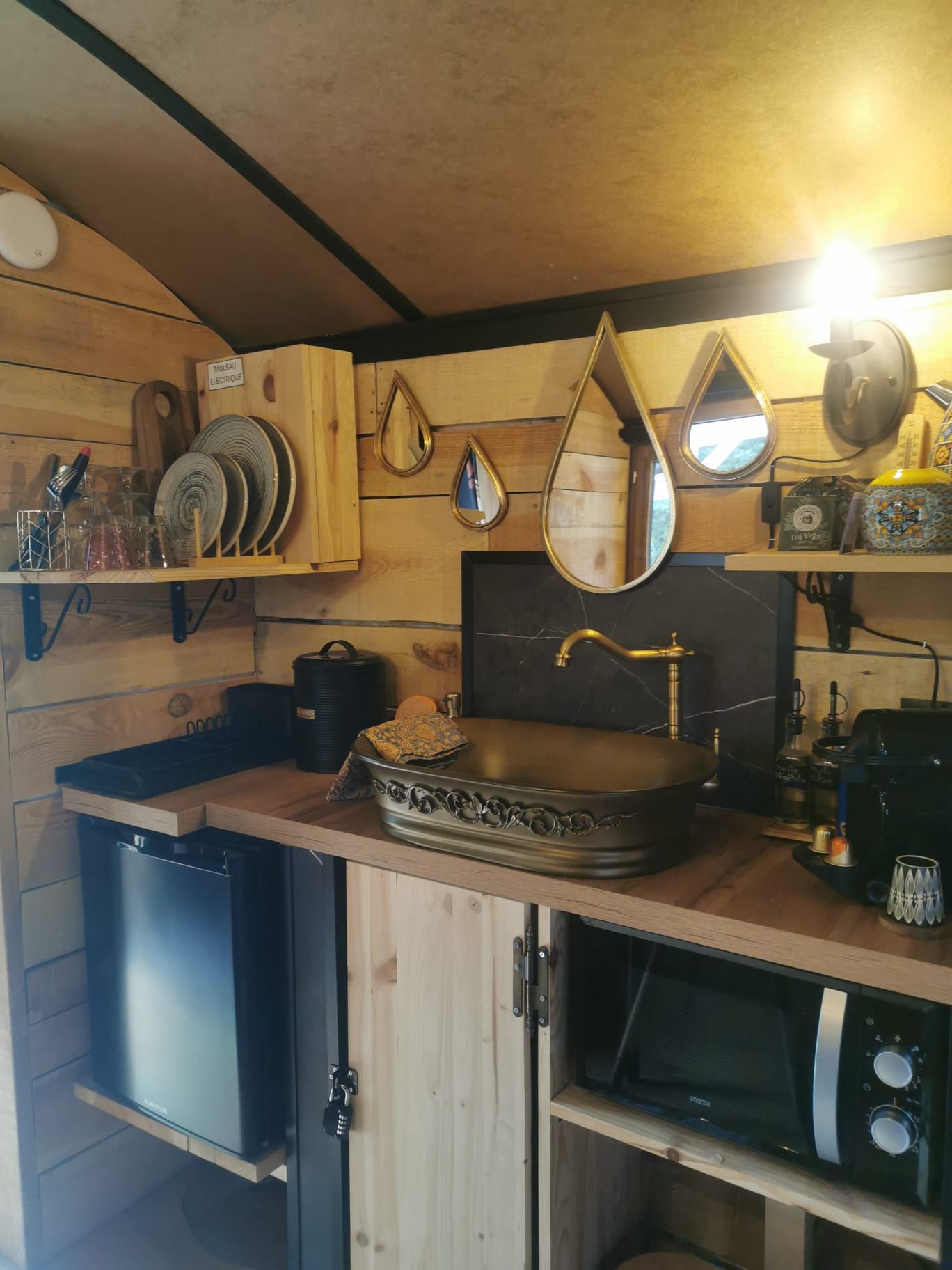 A compact kitchen with a sink, a microwave, and a cabinet.