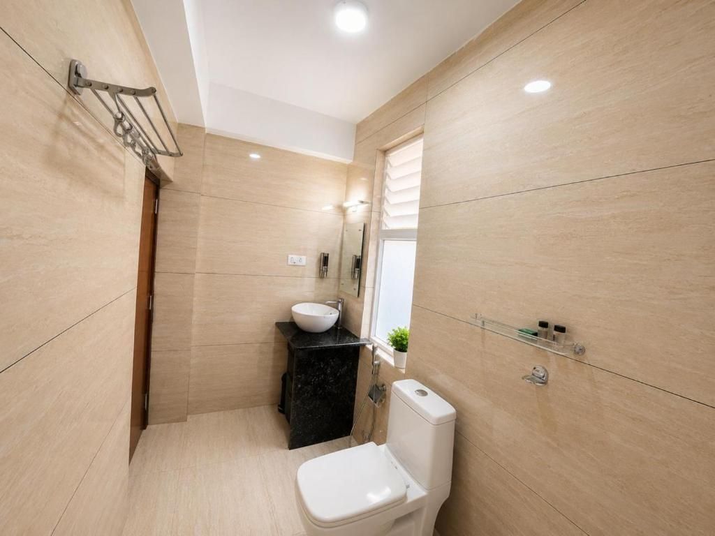 A modern bathroom with a toilet, sink, and mirror.