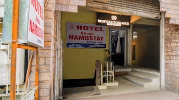 Entrada de un hotel con un letrero que dice 'Hotel Akash Namostay' y una boutique llamada 'Bespoke Elegance Boutique'.