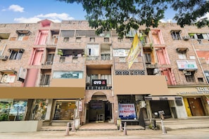 A multi-story building with various commercial establishments on the ground floor, including a hotel and a multi-cuisine restaurant. - Hotel O Akash Namostay (Jamshedpur)