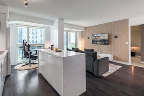 Un apartament modern amb cuina, zona de menjador i saló.