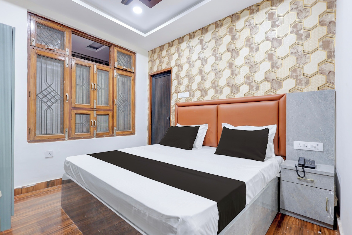 Un dormitorio con cama, armario, mesita de noche y teléfono.
