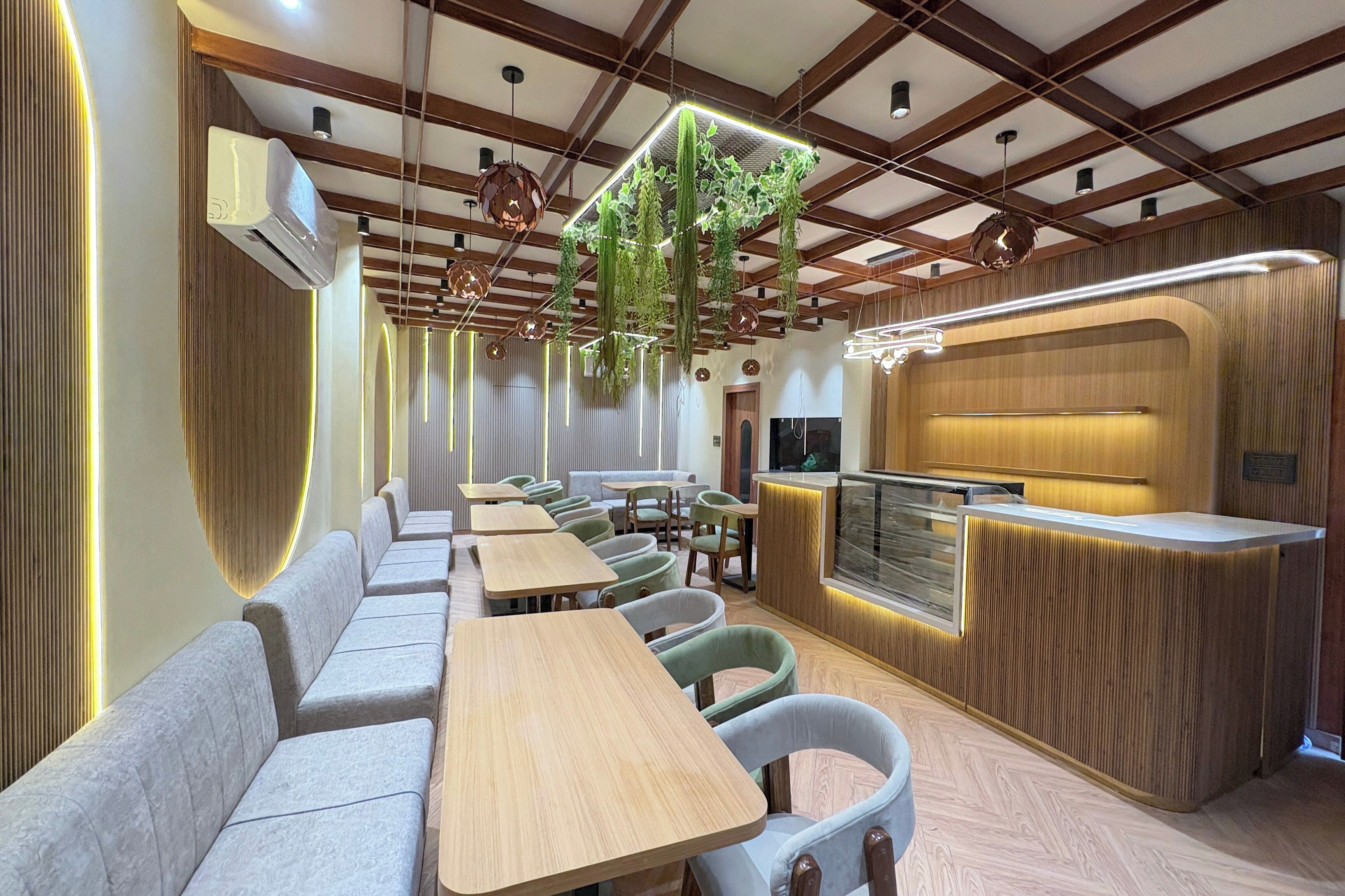 Interior de restaurante con vigas de madera, plantas colgantes y una barra con acabado de madera.