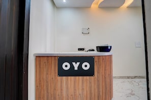 A reception desk with a sign that reads 'OYO' and a black bowl on top. - Hotel O J K Galaxy Hotel (Kanpur)