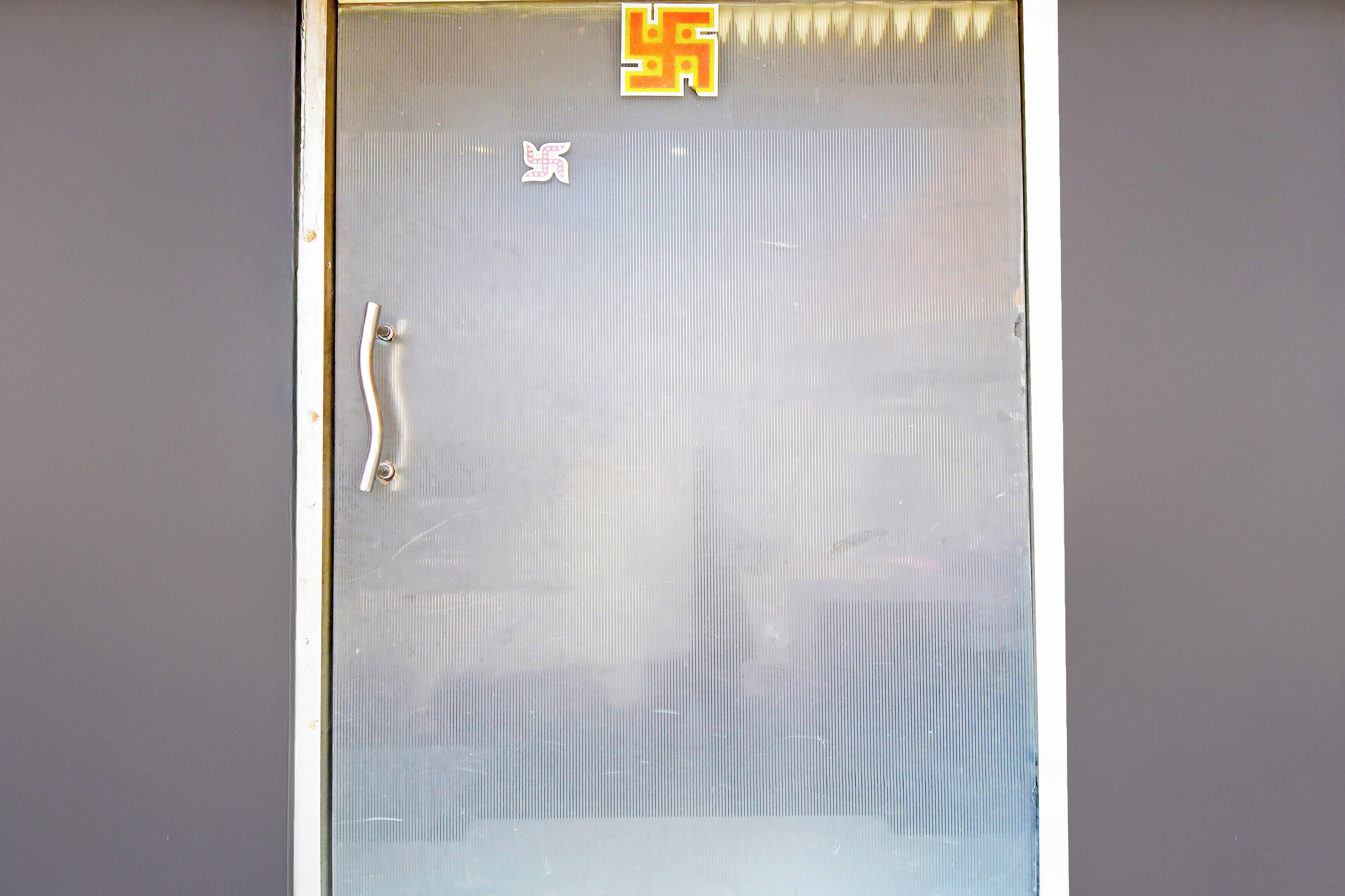 A window with vertical blinds, a handle, and a small decorative item on the blinds.