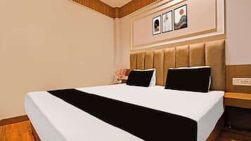 A hotel room with a large bed, a headboard, and a wall-mounted artwork.