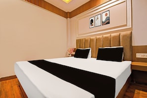 Une chambre d’hôtel avec un grand lit, une tête de lit et une œuvre d’art accrochée au mur.