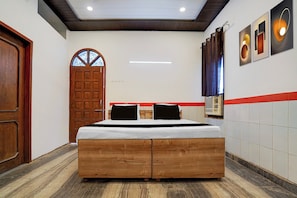 Een slaapkamer met een houten bed, een deur, een raam en een wandairconditioner.
