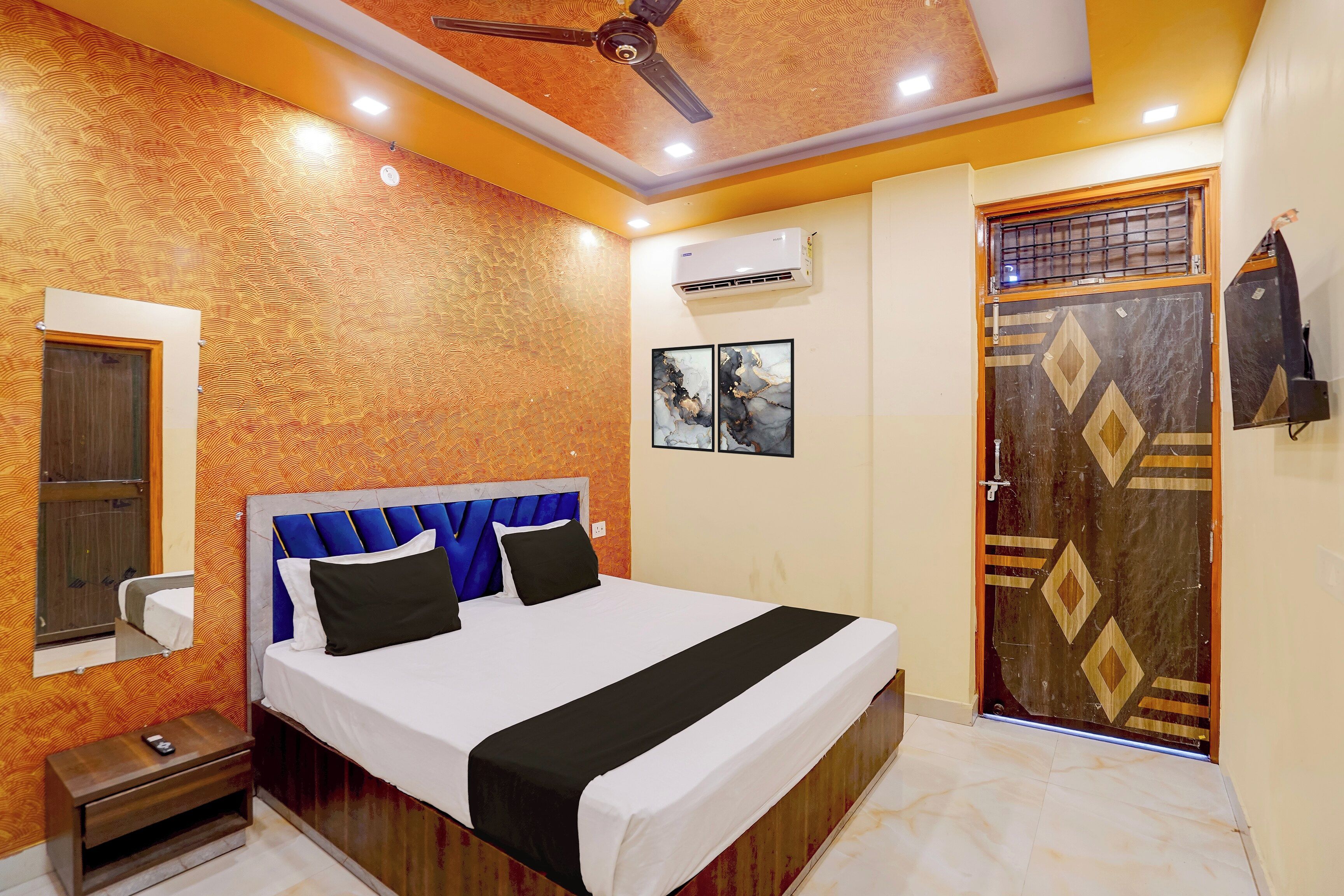 A hotel room with a bed, a nightstand, a wardrobe, and a ceiling fan.