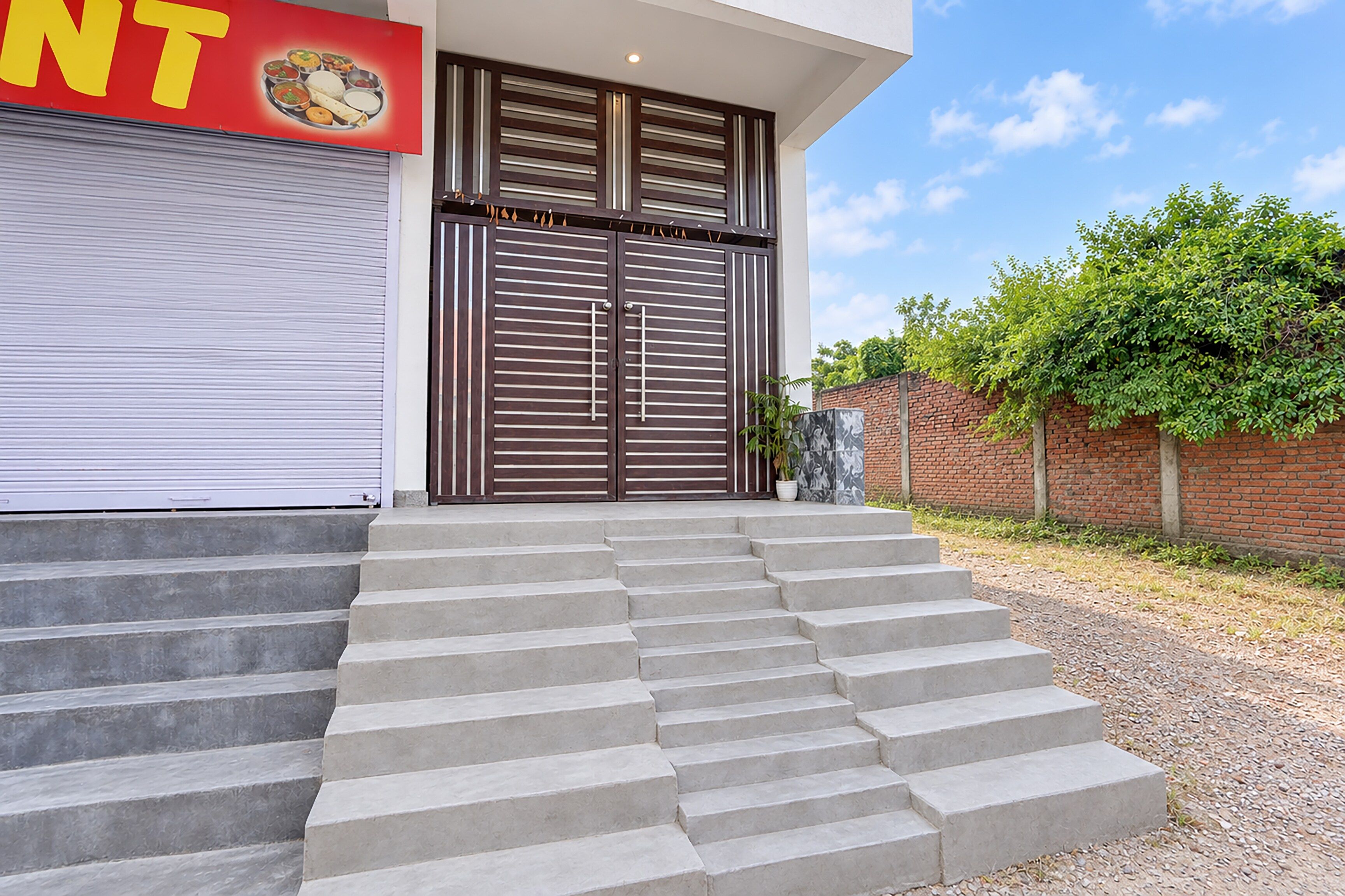 Un edificio moderno con una serie de escalones de hormigón que conducen a una entrada con puertas dobles.