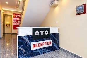 A reception desk with a marble counter and a sign indicating 'OYO HOTEL RAJ INN RESTAURANT'. - Hotel O Raj In (Kanpur)
