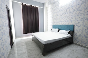 A single bed with a headboard, white bedding, and a window with brown curtains. - Hotel O Meadows (Mandhana)