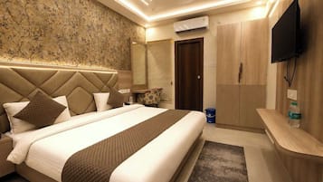 A hotel room with a large bed, a flat-screen TV, a wardrobe, and a ceiling fan.