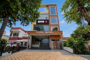 Ein Hotel Eingang mit einem Schild, auf dem 'OYO Hotel Surya' steht.