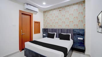 A modern bedroom with a bed, a wardrobe, an air conditioning unit, and a patterned wallpaper.
