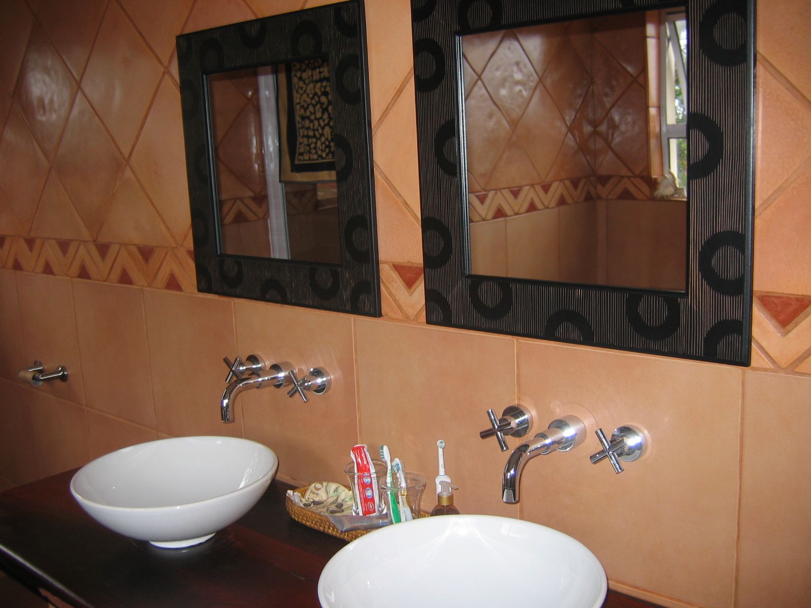 Un baño con dos lavamanos, un espejo y un perchero para toallas.