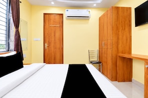 Un dormitorio con cama, armario, silla y equipo de aire acondicionado.