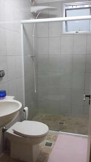 A bathroom with a toilet, sink, and shower. - New Listing (Guarujá)