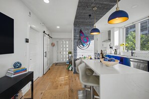 A modern kitchen with a central island, bar stools, and pendant lighting. - Blue Horizon at Longboat Key - 2 bedroom condo with spectacular views (Longboat Key)