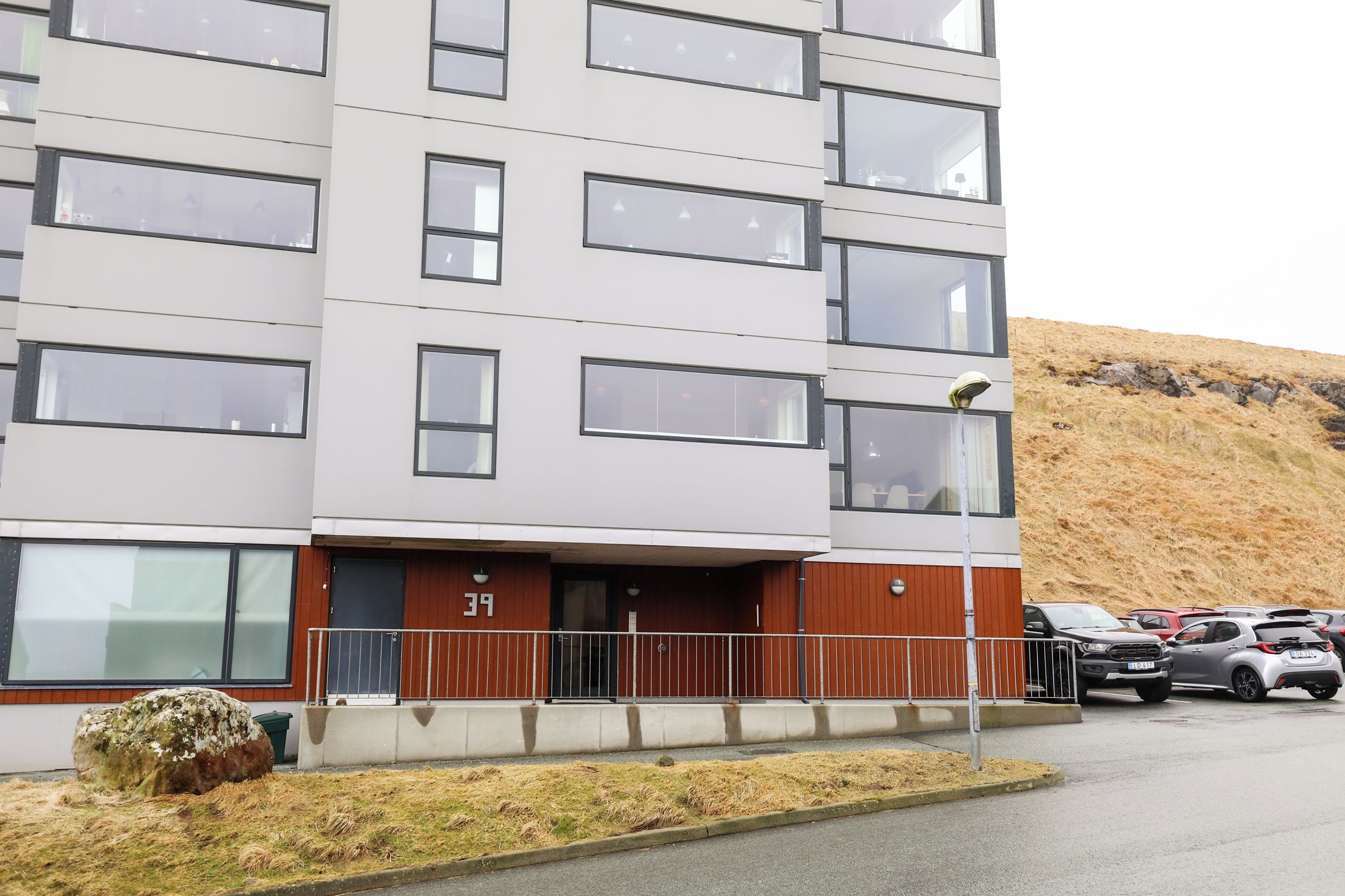 Un edificio de varios pisos con fachada plana, amplias ventanas y una entrada visible con una puerta numerada 39.