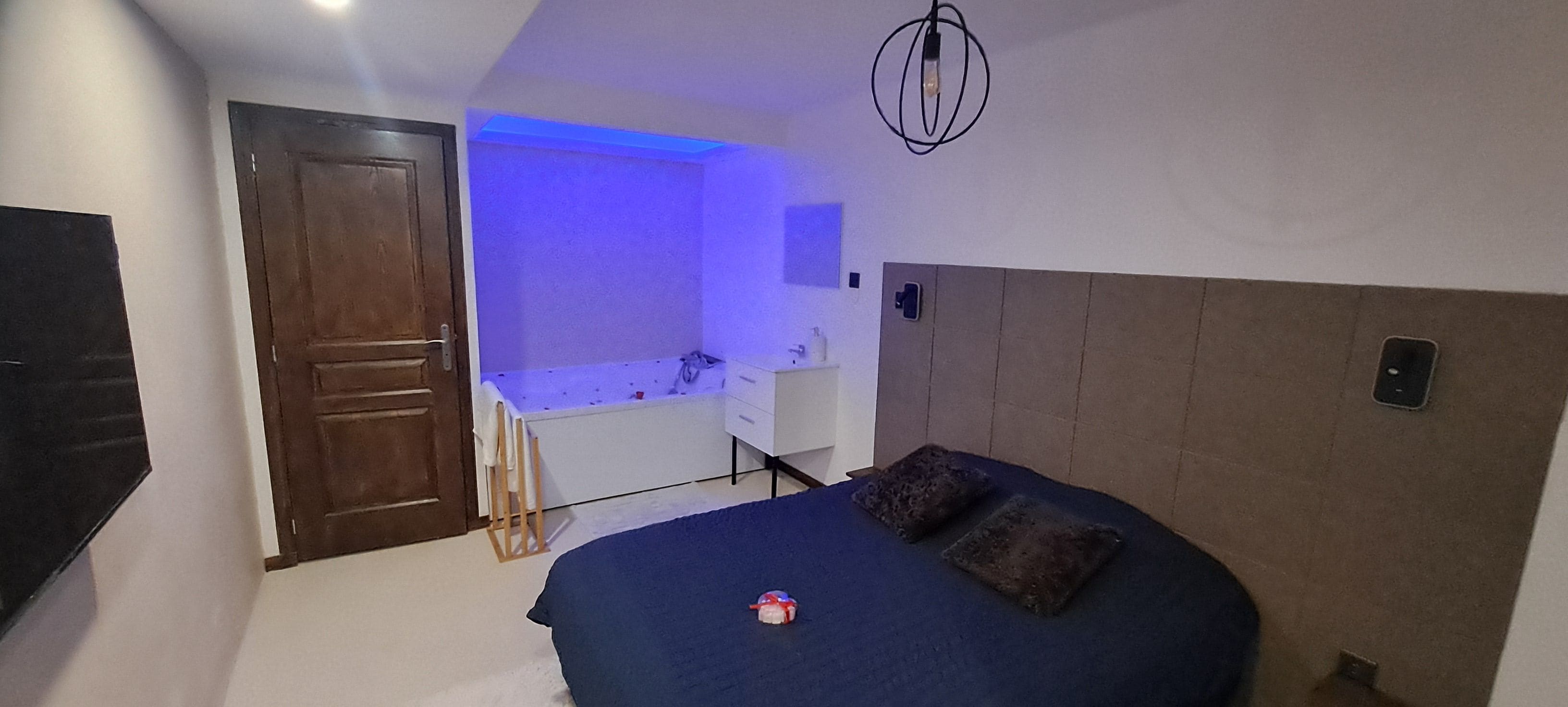 Une chambre à coucher avec un lit, un bureau et une salle de bain.