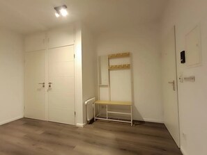 Ein Zimmer mit geschlossenem Kleiderschrank, einer Sitzbank und einem Heizkörper.