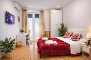 A hotel room with a bed, a desk, a chair, a television, and a window with curtains. - NEXT Palace (Roma)