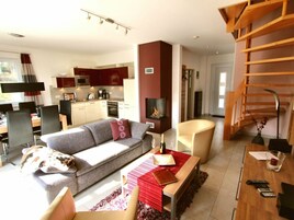 Una sala moderna con un sofá, una mesita roja de acento y una chimenea.