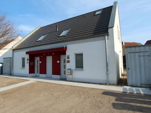 A building with a red awning, a door, and a window. - Holiday Home Fohlenweide (Goehren-Lebbin)