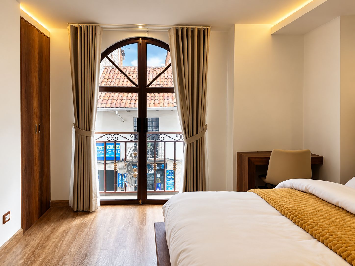 Un dormitorio con cama, una mesita de noche y vistas a un balcón con barandilla.