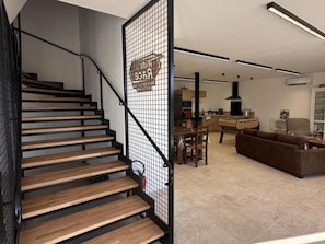 A modern interior with a wooden staircase, a dining area, and a living space.