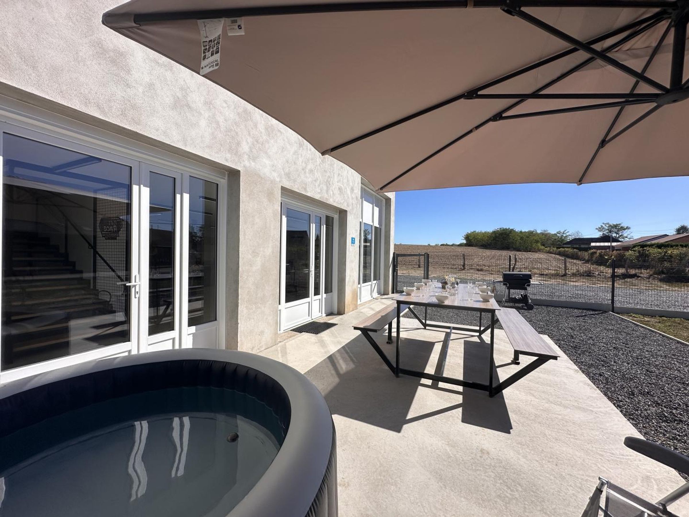A poolside area with a hot tub, outdoor seating, and a covered patio.