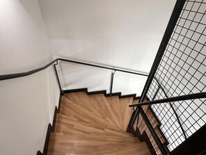 Un escalier en bois avec des rampes noires et un plafond blanc.