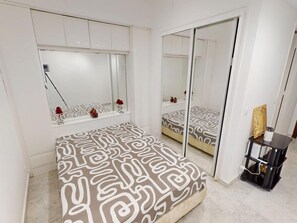 A bedroom with a bed, a mirror, a wardrobe, and a bedside table. - Studio with AC and terrace - 2 guests (Menton)