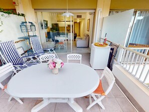 An outdoor patio with a white table and chairs, a small white cabinet, and a glass door leading to an interior space. - Studio with AC and terrace - 2 guests (Menton)