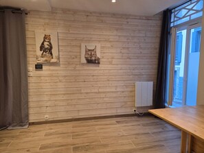 A room with wooden panel walls, a window with blinds, a radiator, and a wooden bench. - Central studio - 4 guests (Cauterets)
