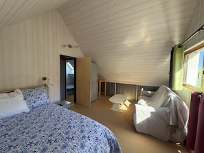 A bedroom with a bed, a chair, a small table, and a wardrobe. - Duplex apartment in the resort center - 7 to 9 guests. (Le Lioran)