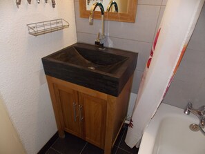 A bathroom with a wooden vanity, a sink, and a mirror. - Studio in the center - 4 guests (Pralognan-la-Vanoise)