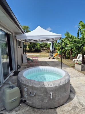 A backyard with a covered patio, a hot tub, and a slide. - New Listing (Sainte-Anne)
