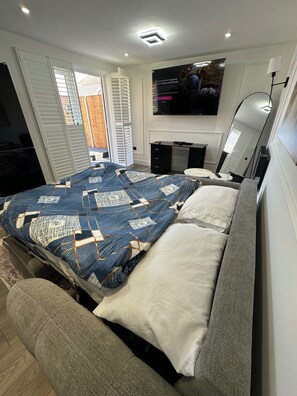 Une chambre à coucher avec un lit, une télévision, un bureau et une chaise.