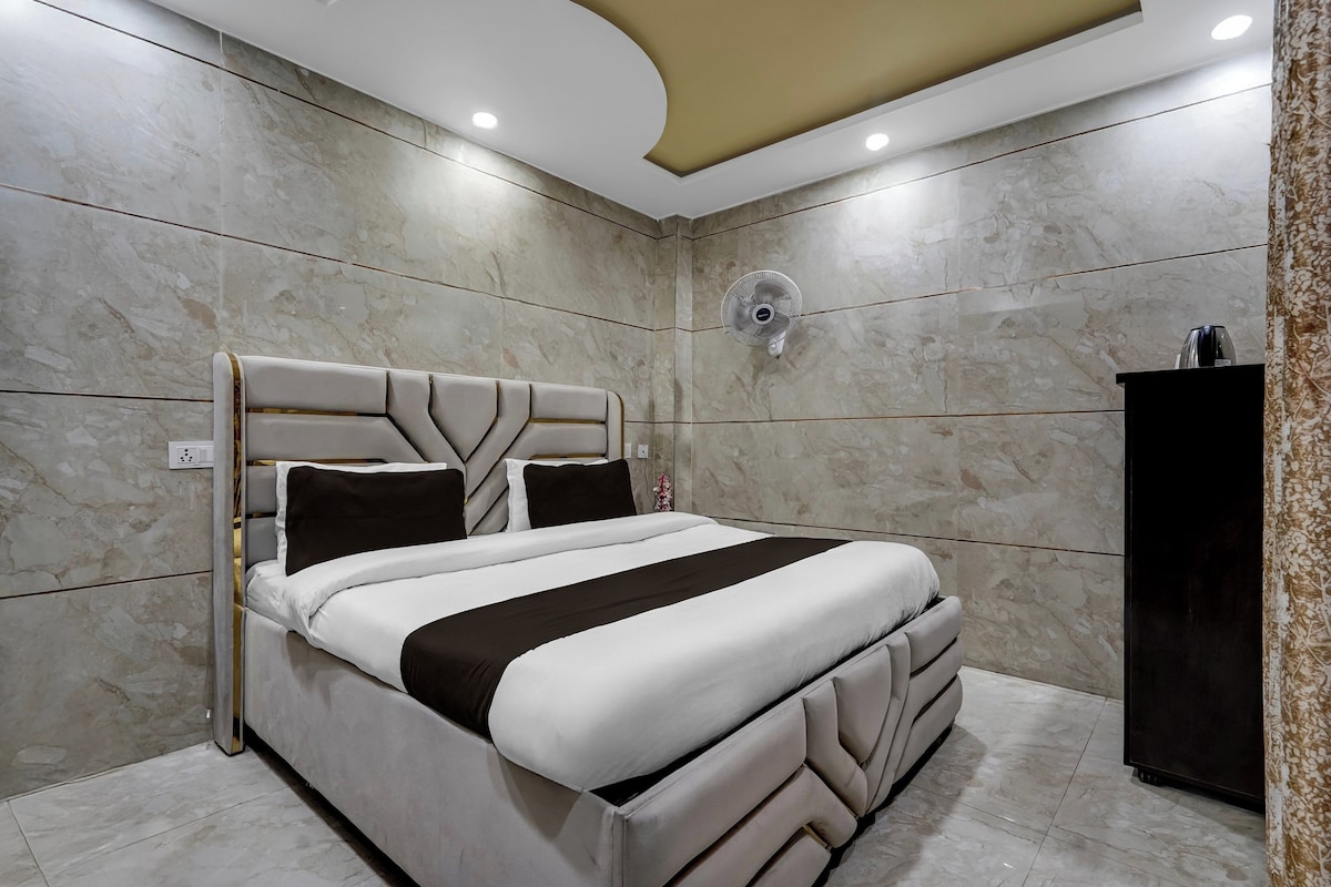 Un dormitorio moderno con una cama grande, un ventilador de techo y un armario oscuro.