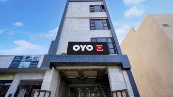 A hotel entrance with a sign for 'OYO Hotel MV Grand'.
