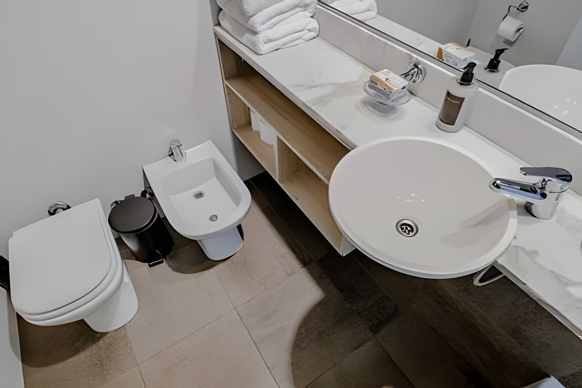 A modern bathroom with a toilet, bidet, and sink.