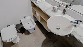 A modern bathroom with a toilet, bidet, and sink.