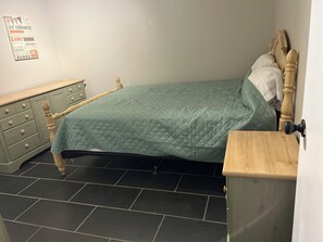 A bedroom with a bed, a dresser, and a nightstand. - Enjoyable 3-bedroom house with AC in charming Mobile (Mobile)